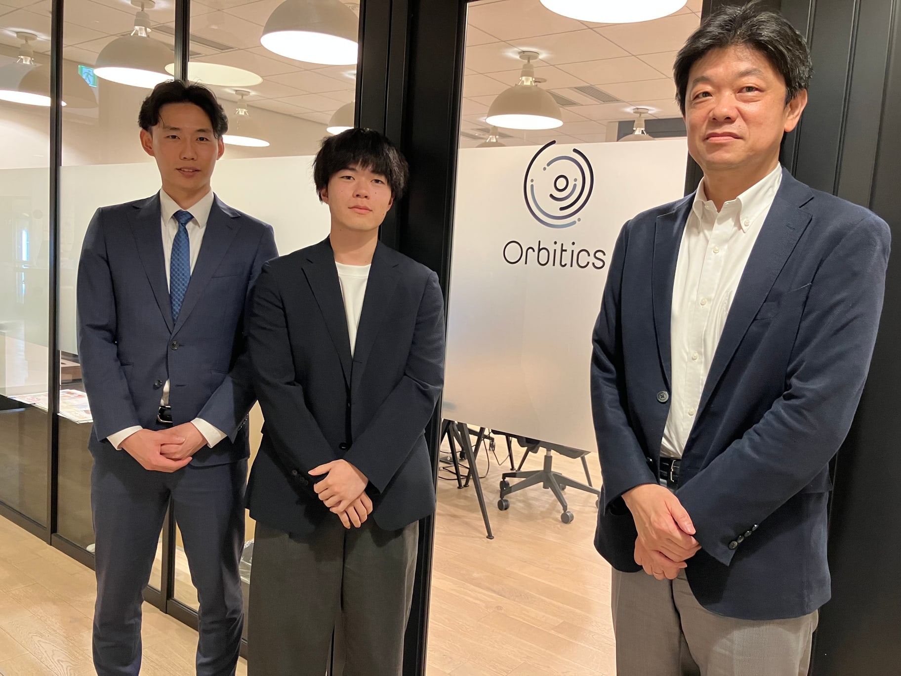 Orbiticsロゴを囲むプロジェクトメンバー